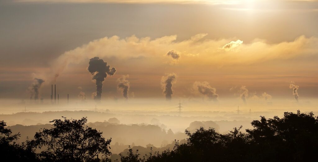 Image of industry with smoke rising from factory chimneys.