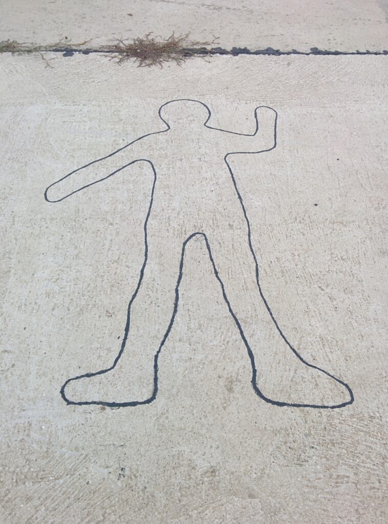 outline of body sketched on pavement