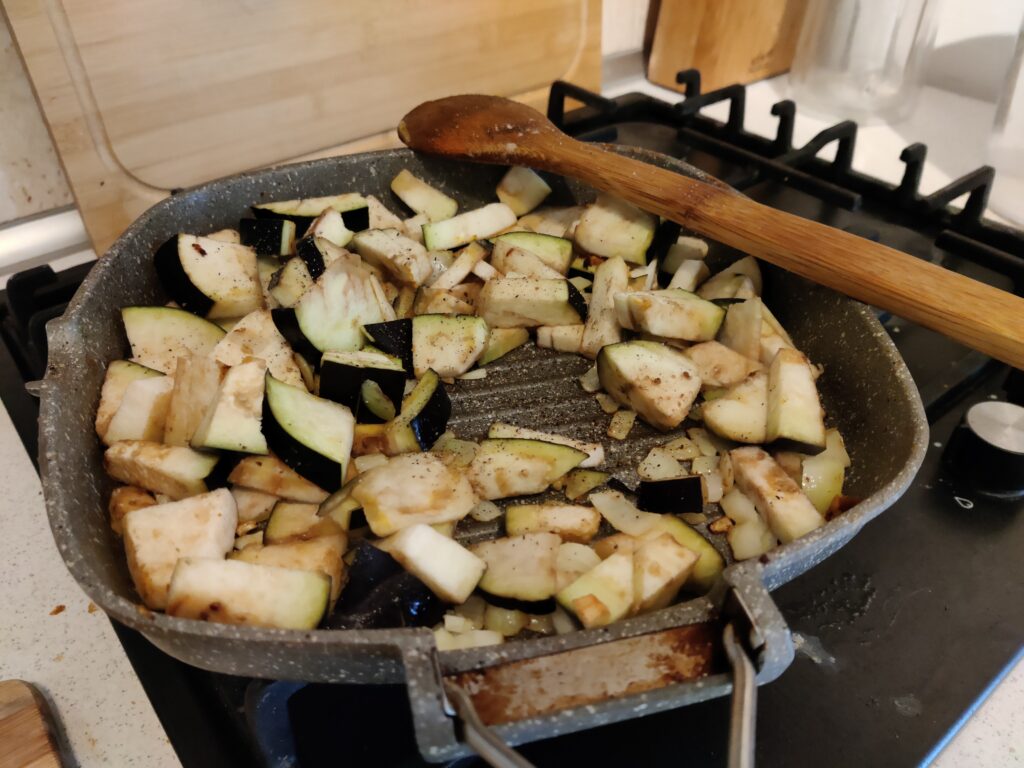 Aubergines frying in a pan.