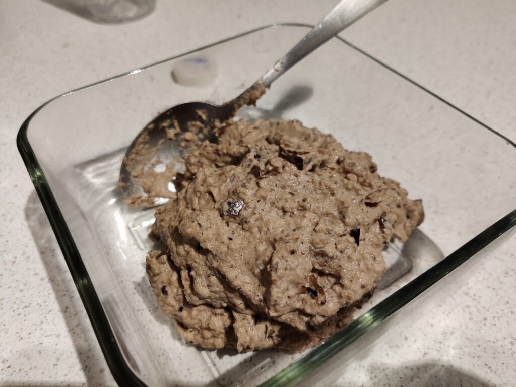 Aubergine and walnut pate in a glass container.