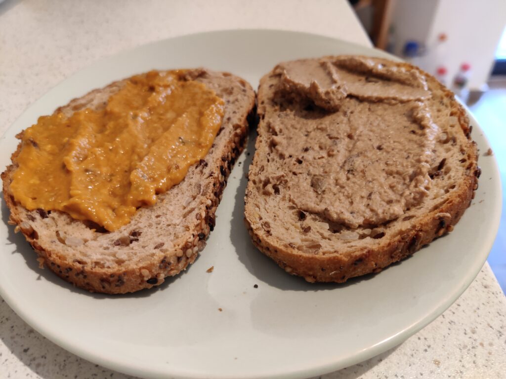 Two slices of toast, one with bean pate, the other aubergine pate.